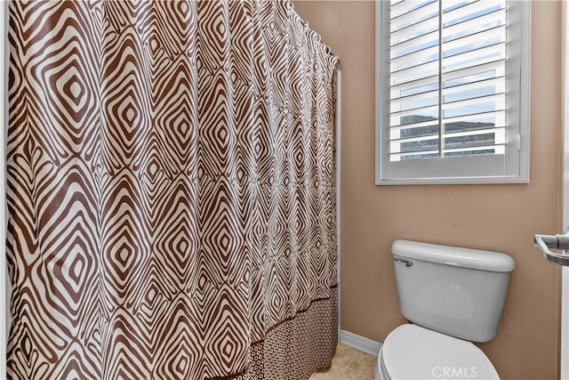 bathroom with toilet, a shower with shower curtain, and tile patterned flooring