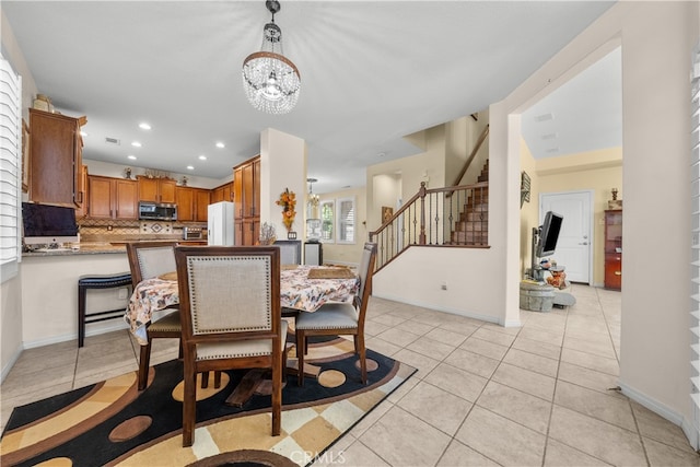 tiled dining room featuring an inviting chandelier