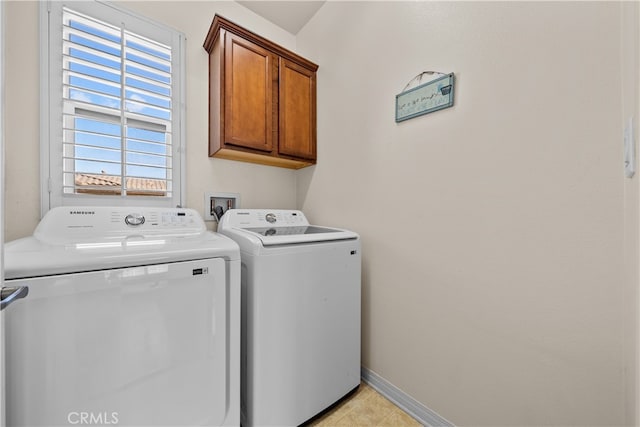 washroom featuring cabinets and washer and clothes dryer