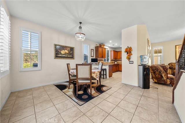 tiled dining room featuring a notable chandelier