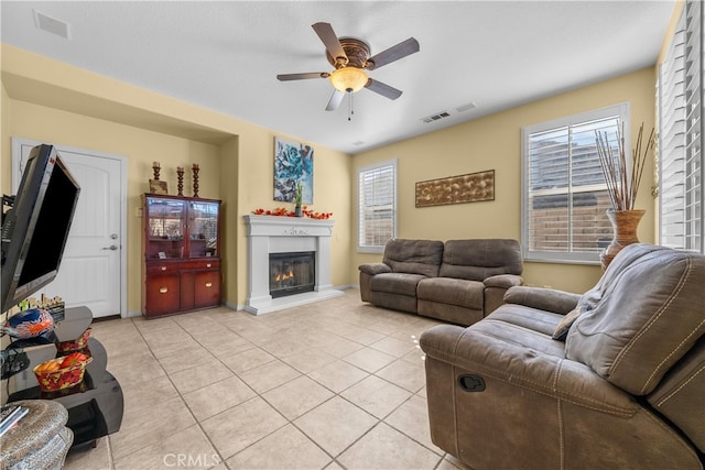 tiled living room with ceiling fan and plenty of natural light