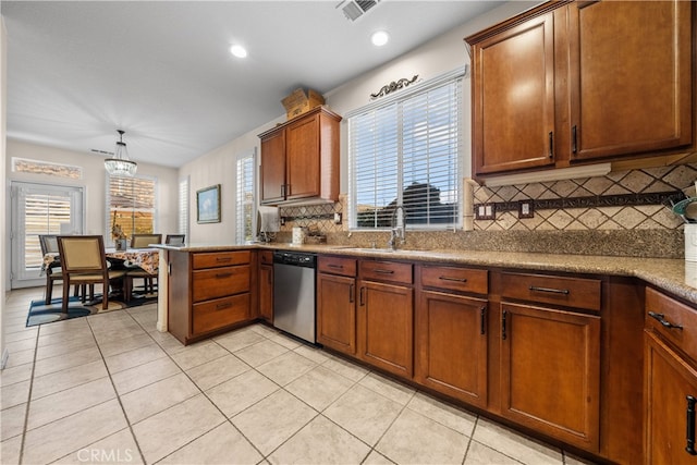 kitchen featuring stainless steel dishwasher, sink, hanging light fixtures, and plenty of natural light