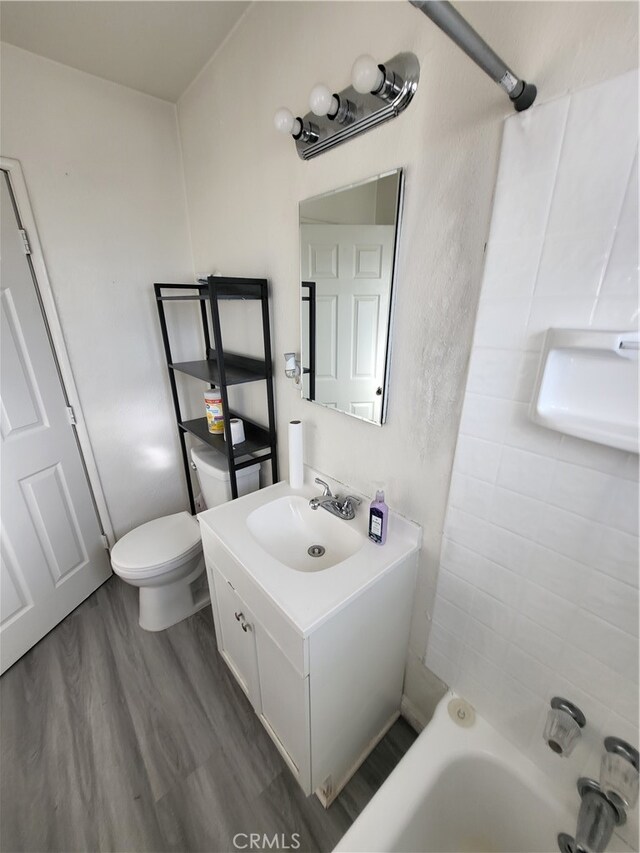 full bathroom with toilet, shower / washtub combination, vanity, and wood-type flooring