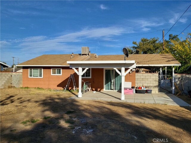 back of property with a patio and central AC