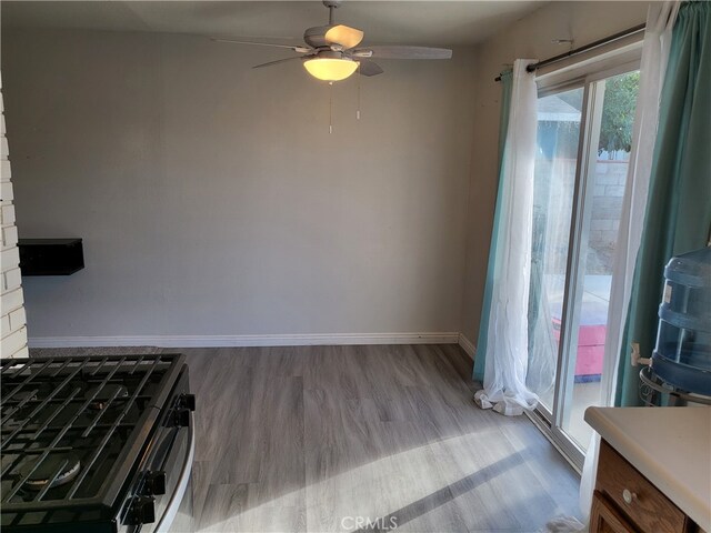 interior space with stainless steel range oven, light wood-type flooring, and ceiling fan