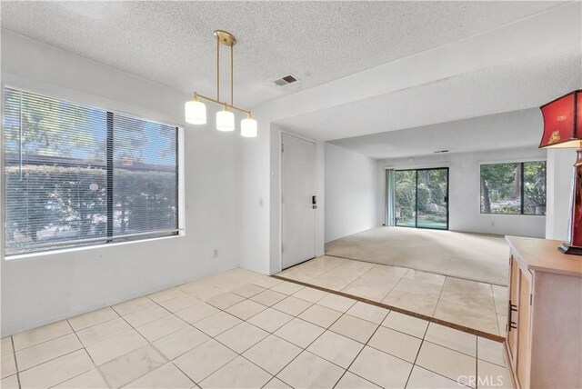 unfurnished room with light tile patterned floors and a textured ceiling