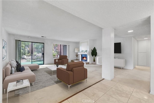 living room with a textured ceiling and light tile patterned flooring