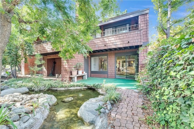 back of house featuring a balcony and a patio area