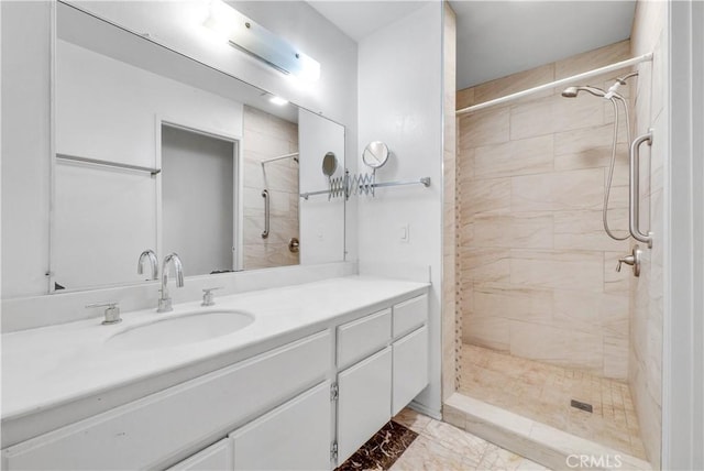 bathroom with a tile shower and vanity