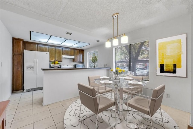 dining area with a textured ceiling and light tile patterned flooring