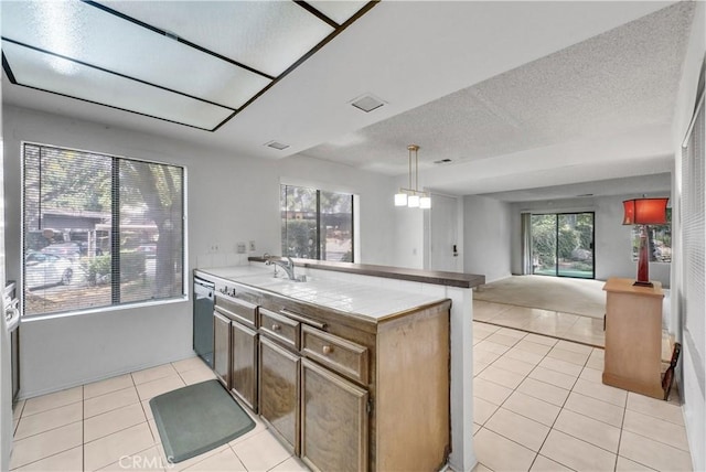 kitchen featuring light tile patterned floors, tile countertops, kitchen peninsula, hanging light fixtures, and a wealth of natural light