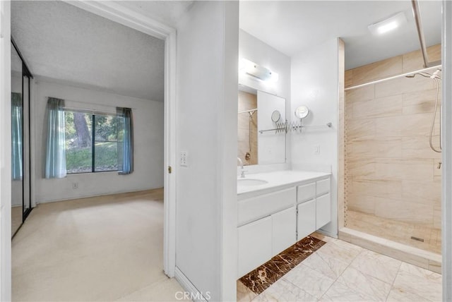 bathroom with vanity and tiled shower