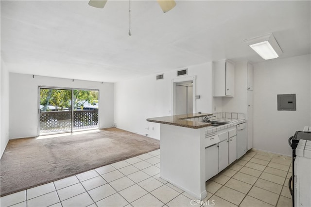 kitchen with light carpet, dishwasher, kitchen peninsula, and white cabinets