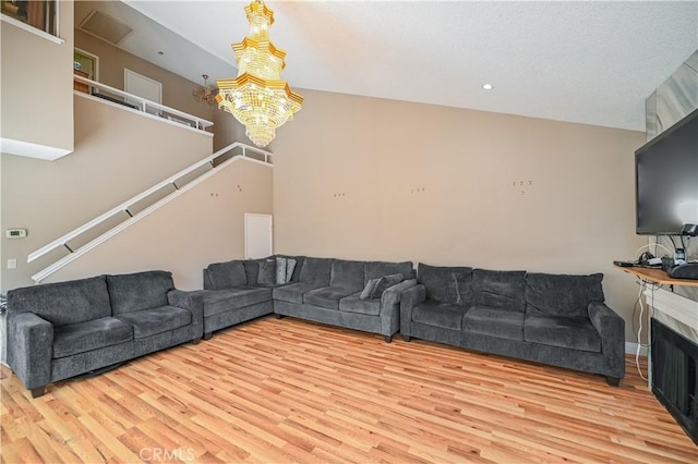 living room featuring hardwood / wood-style floors, an inviting chandelier, and lofted ceiling