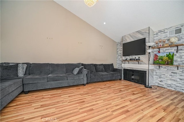 living room featuring a fireplace, light hardwood / wood-style flooring, and lofted ceiling