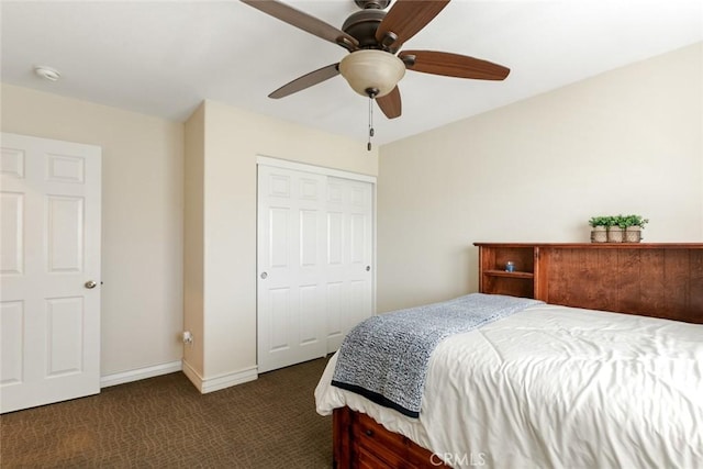 bedroom with a ceiling fan, dark colored carpet, a closet, and baseboards