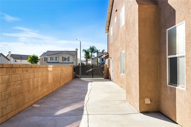 view of home's exterior with fence, a gate, and stucco siding