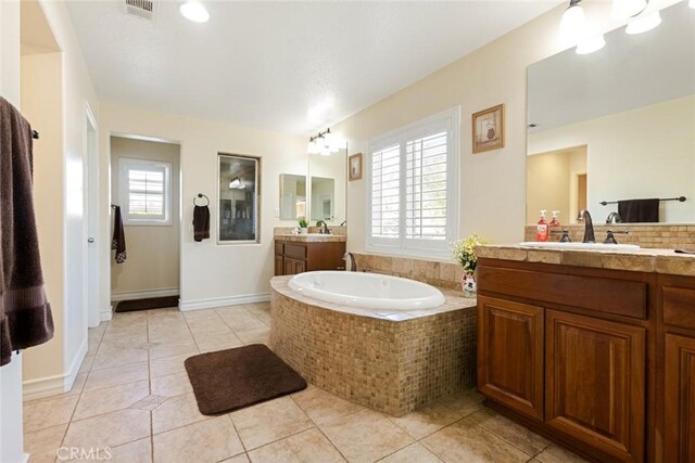 bathroom featuring tile patterned floors, vanity, and a healthy amount of sunlight