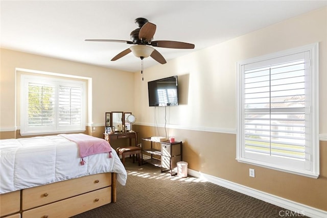 bedroom with ceiling fan, dark carpet, and baseboards