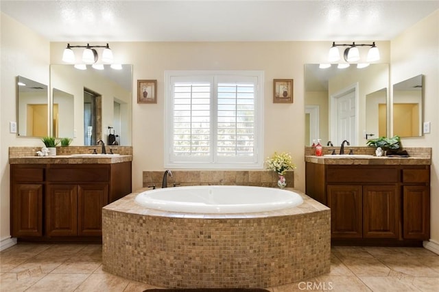 full bathroom with a garden tub, two vanities, a sink, and tile patterned floors