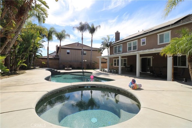 view of swimming pool with a patio area, fence, a fenced in pool, and an in ground hot tub