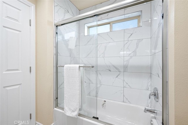 bathroom with combined bath / shower with glass door