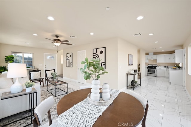 dining room featuring ceiling fan and sink