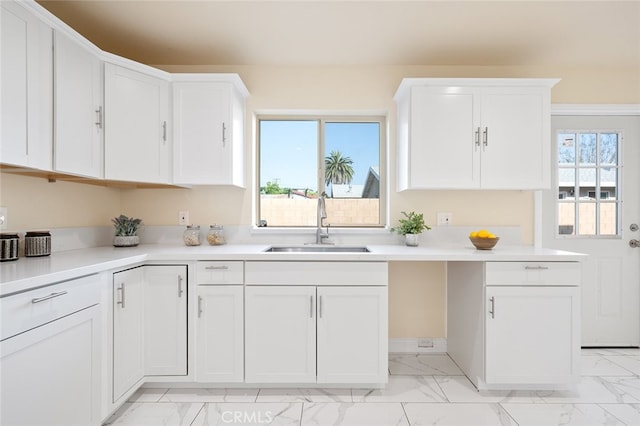 kitchen featuring white cabinetry and sink