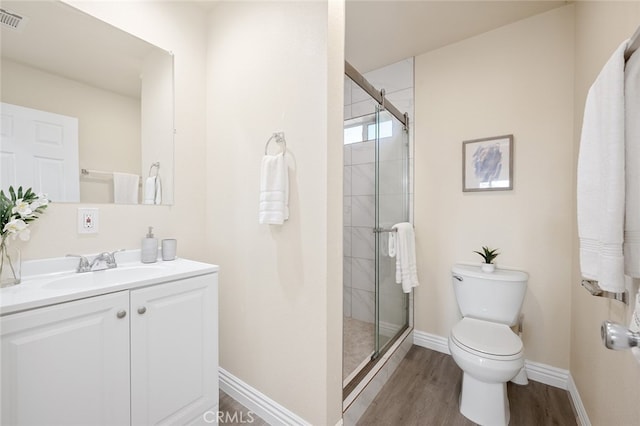 bathroom with a shower with door, toilet, hardwood / wood-style floors, and vanity