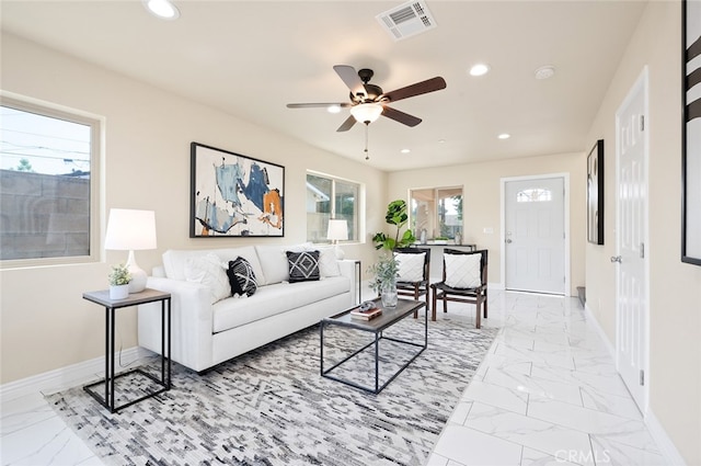 living room featuring ceiling fan and a wealth of natural light