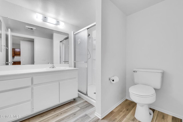 bathroom featuring vanity, hardwood / wood-style floors, toilet, and walk in shower