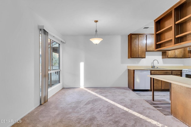 kitchen with sink, dishwashing machine, decorative light fixtures, and light colored carpet