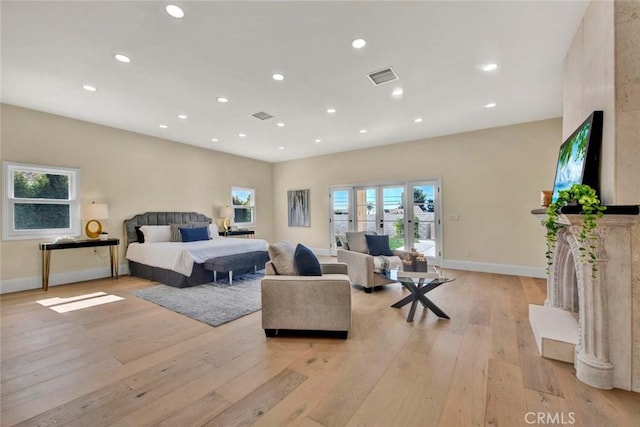 bedroom with french doors and light hardwood / wood-style flooring