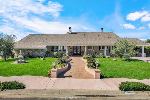 ranch-style house featuring a front yard and french doors