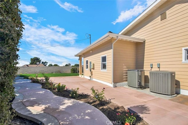 view of side of home featuring cooling unit and a patio