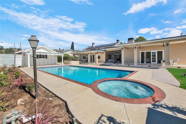 view of swimming pool with a patio area, an in ground hot tub, ceiling fan, and an outdoor structure