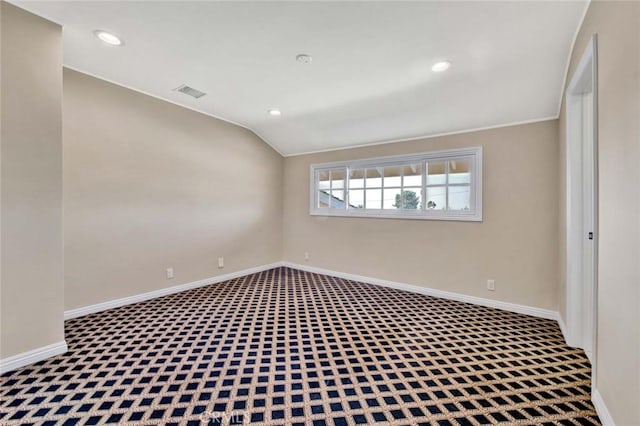 carpeted spare room with vaulted ceiling