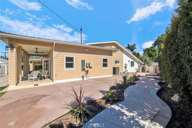 rear view of property featuring ceiling fan, cooling unit, and a patio