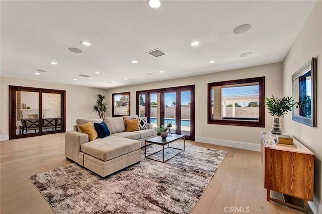 living room featuring french doors and light hardwood / wood-style floors