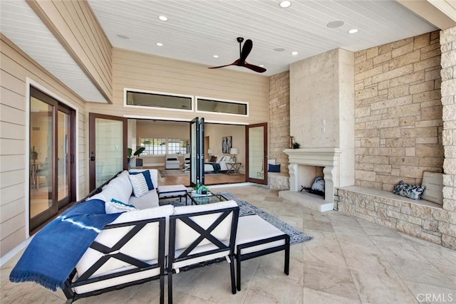 view of patio with an outdoor living space with a fireplace and ceiling fan