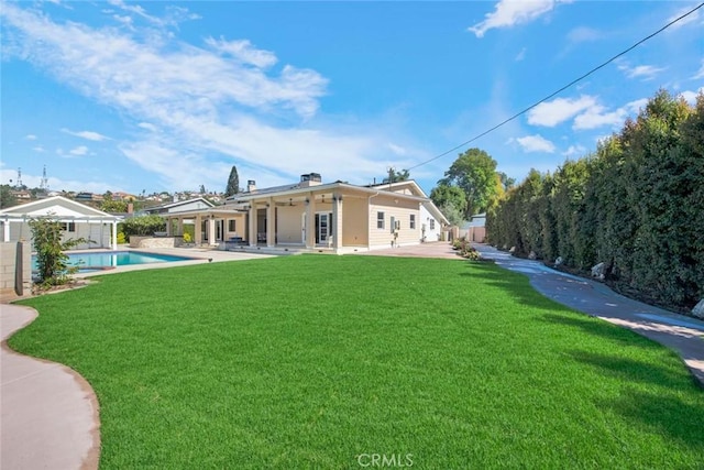 back of property featuring a fenced in pool, a yard, and a patio