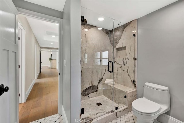 bathroom featuring hardwood / wood-style floors, toilet, and an enclosed shower