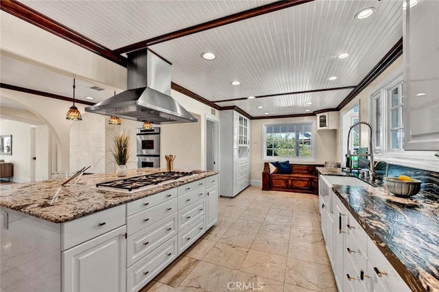 kitchen featuring wall chimney exhaust hood, dark stone countertops, white cabinetry, and appliances with stainless steel finishes