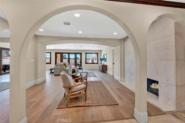 foyer entrance featuring a tile fireplace and light hardwood / wood-style flooring