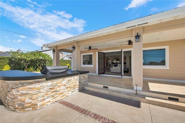 view of patio / terrace with an outdoor kitchen, area for grilling, and ceiling fan