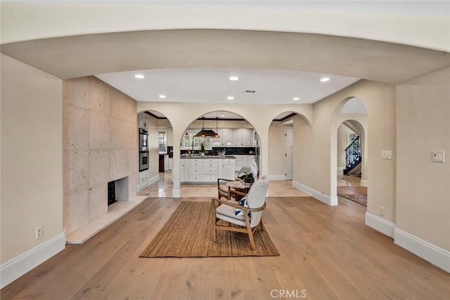 living area with a fireplace and light hardwood / wood-style flooring