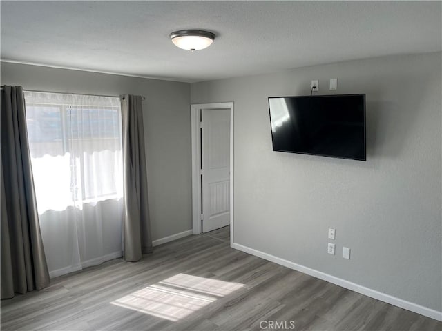 13165 Caspian Dr, Victorville, CA 92395 - unfurnished bedroom with baseboards, wood finished floors, and a textured ceiling