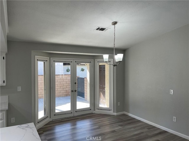 13165 Caspian Dr, Victorville, CA 92395 - unfurnished dining area with french doors, dark wood finished floors, baseboards, visible vents, and a notable chandelier