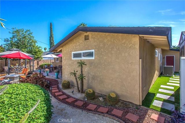 view of home's exterior with a patio area and central AC unit