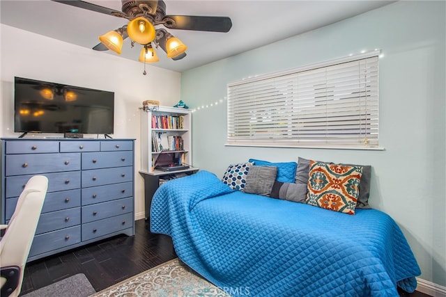 bedroom with dark hardwood / wood-style floors and ceiling fan